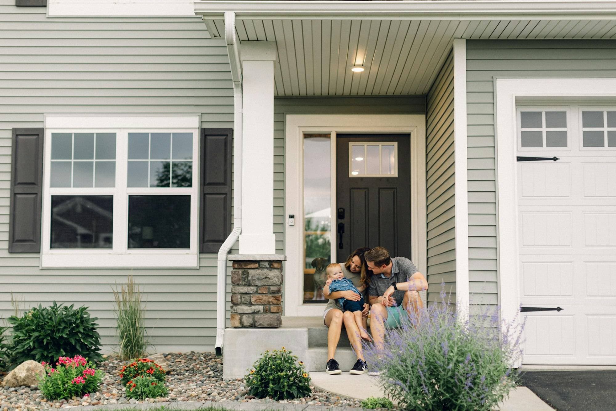 A family sitting together on the front steps of their home